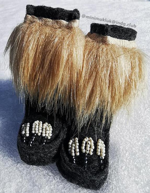 Sitting on snow a pair of dark grey felted boots. Each feature three white beaded arrow heads. Hematite beads for the arrow shafts. Contrasting blonde fur and white shoelace trim. Time permitting I would like to create matching dolls for all these styles